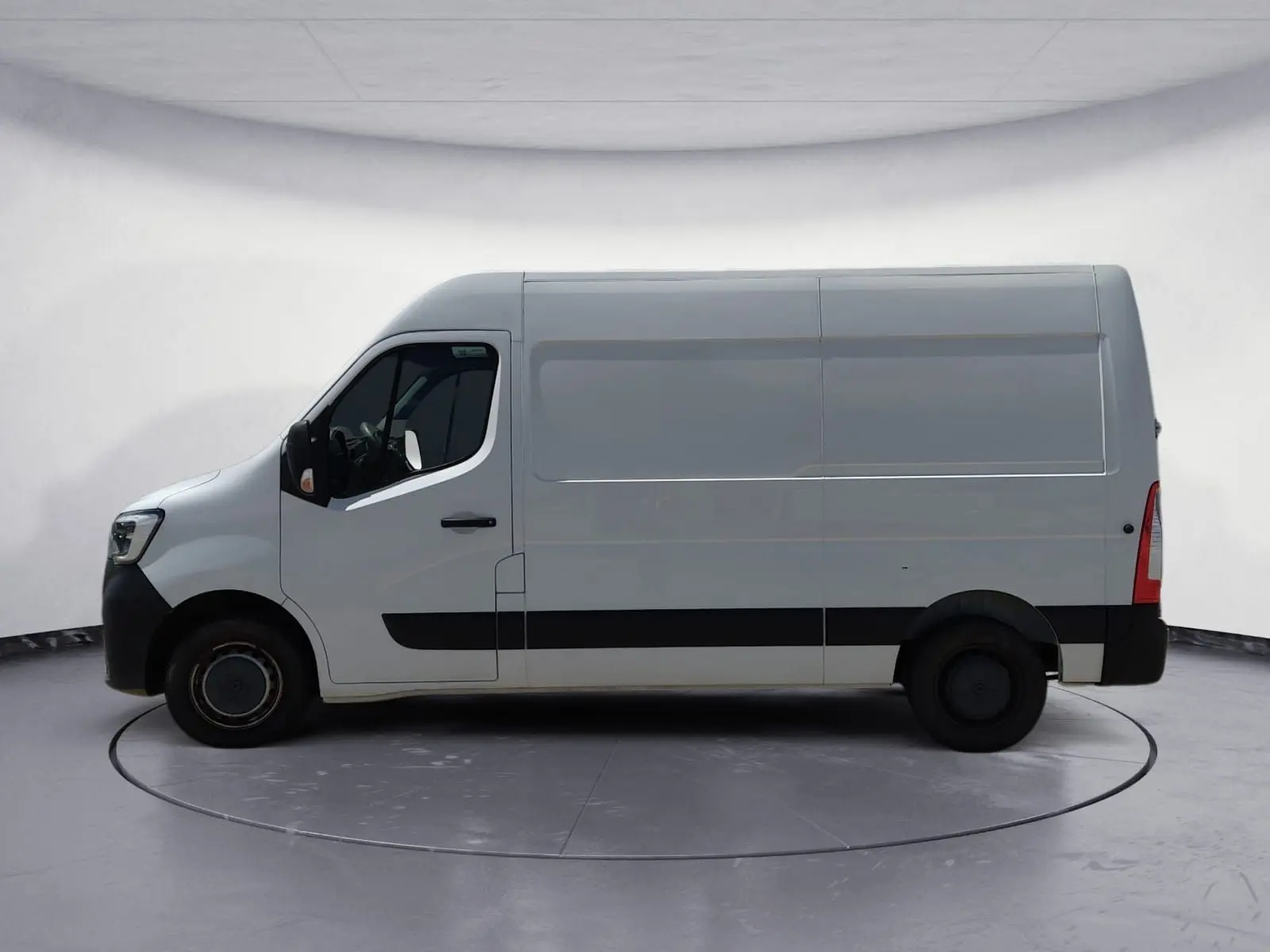 Vue de profil côté gauche d’un Renault Master blanc L2H2, fourgon utilitaire avec bande noire basse et roues noires.