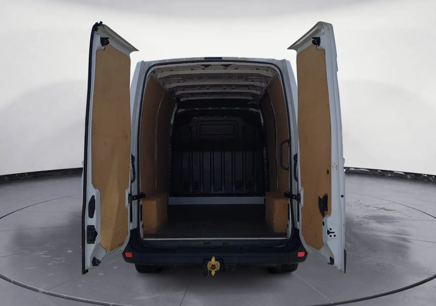 Vue arrière du Renault Master blanc L2H2 2022 avec portes ouvertes montrant l’espace de chargement vide et habillage bois intérieur.