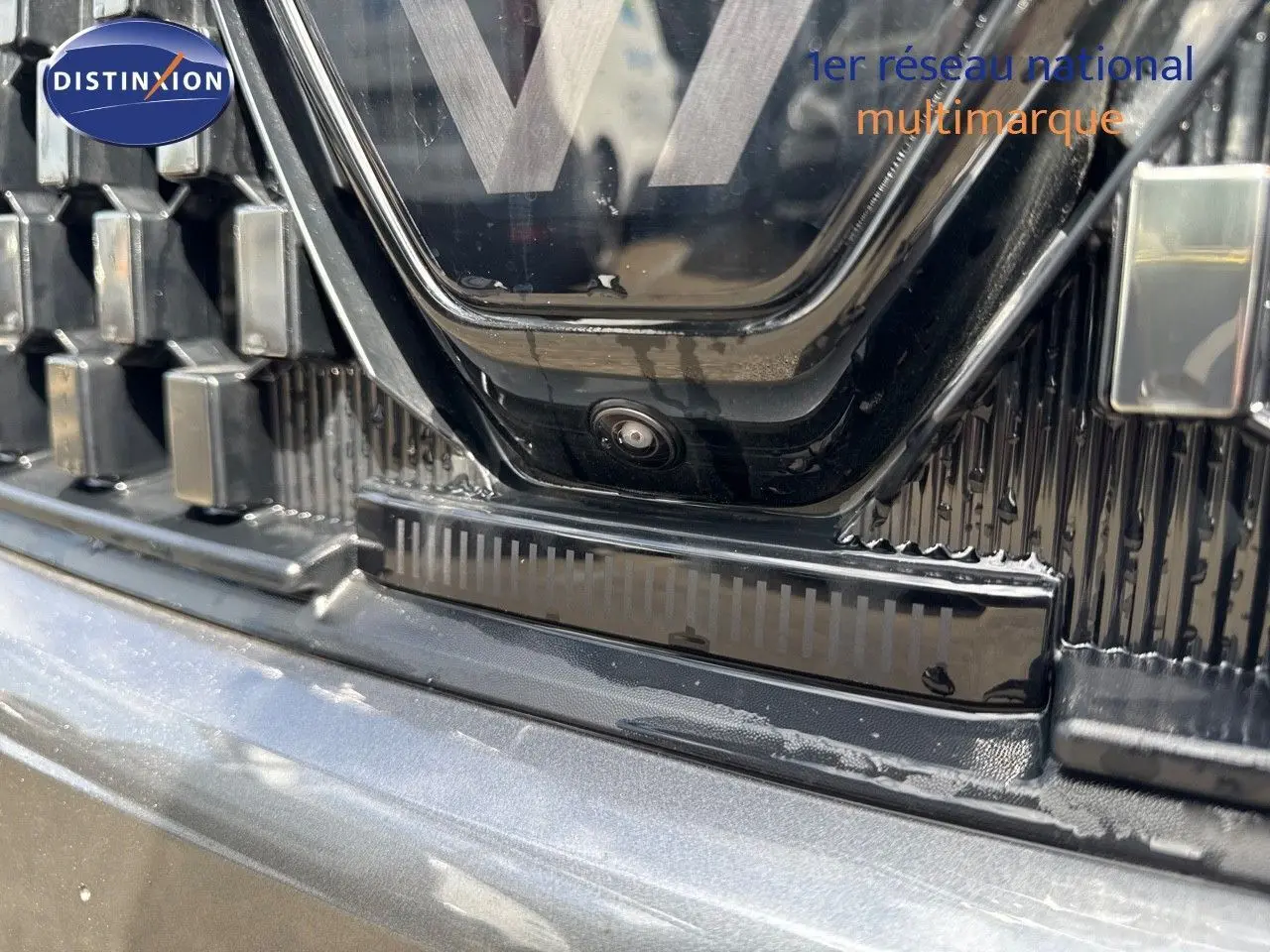 Gros plan sur la calandre grise schiste métal avec caméra avant du Renault Austral 2024 toit noir.