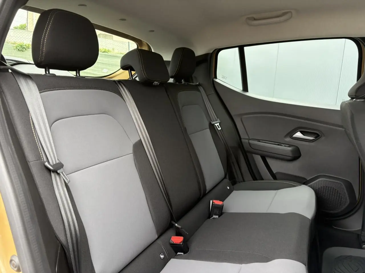 Vue intérieure côté droit des sièges arrière en tissu gris et noir de la Dacia Sandero Stepway Beige Safari 2025.