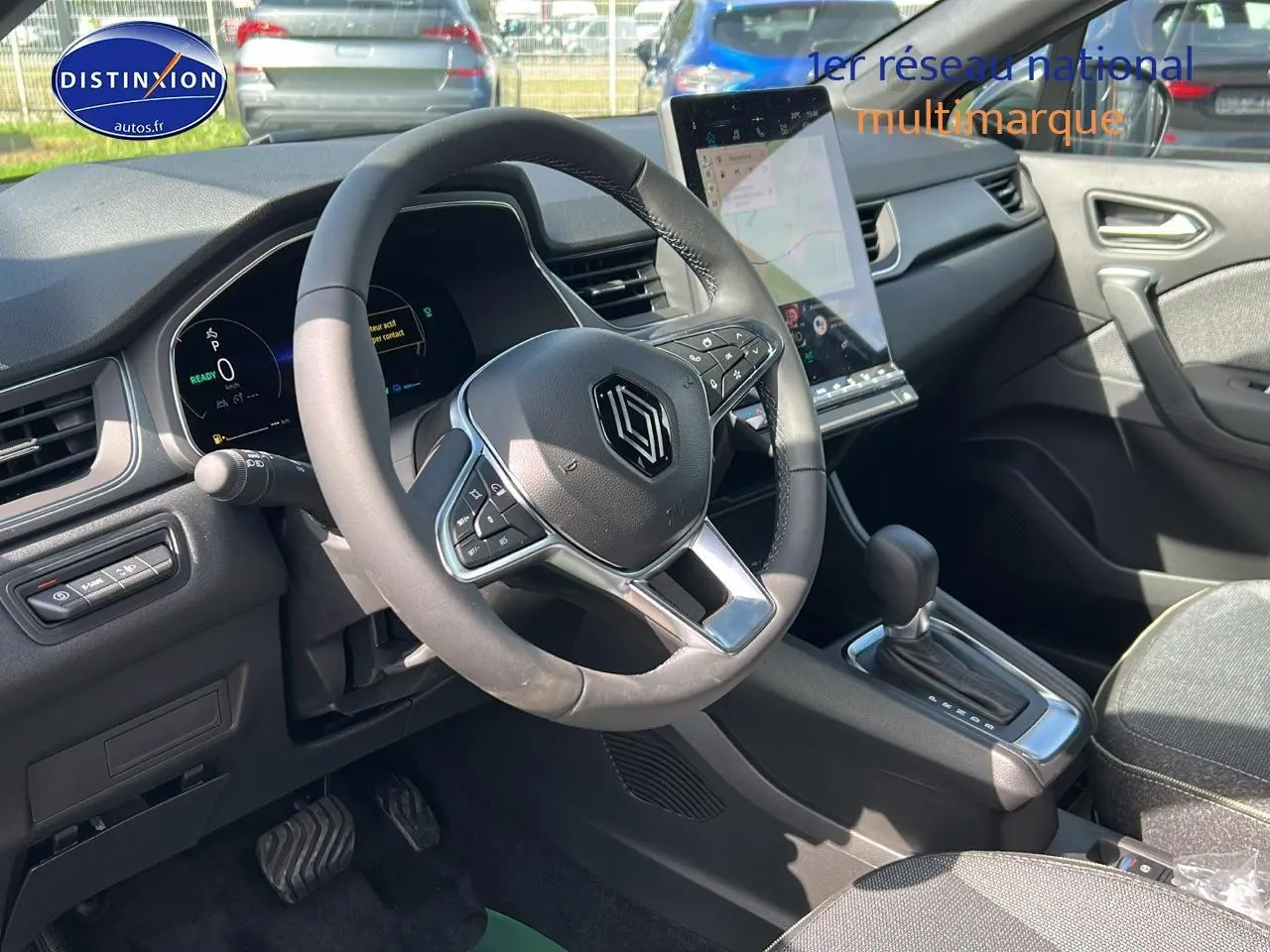 Vue intérieure côté conducteur du tableau de bord et volant du Renault Captur 1.6 e-tech hybride 2025 avec écran tactile vertical.