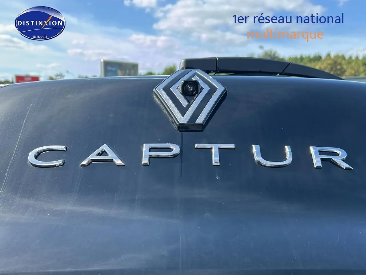 Gros plan sur le logo Renault et l’inscription Captur en chrome sur la malle arrière noire étoile du véhicule.
