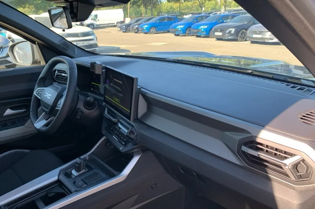 Vue intérieure côté conducteur du tableau de bord et volant du Dacia Bigster 155 Journey avec écran tactile central.