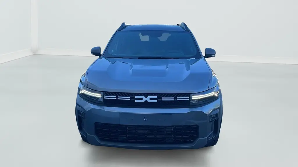 Vue avant du Dacia Bigster 155 Journey gris schiste avec signature lumineuse en Y à LED et calandre noire.