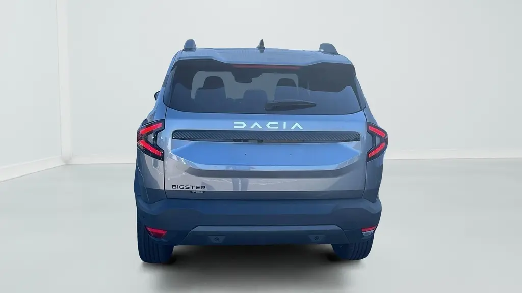 Vue arrière du Dacia Bigster gris schiste 2026 avec feux arrière en forme de flèche et logo lumineux DACIA.