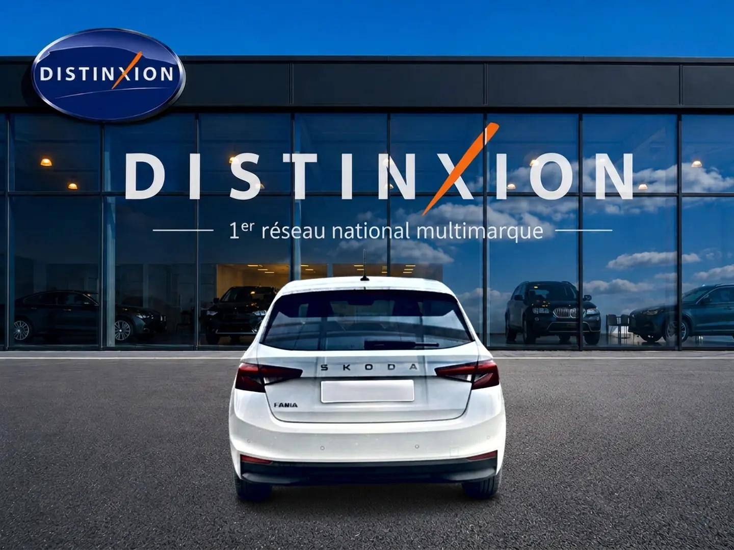 Vue arrière d'une Skoda Fabia blanche 2025 garée devant une vitrine avec logo Distinxion.