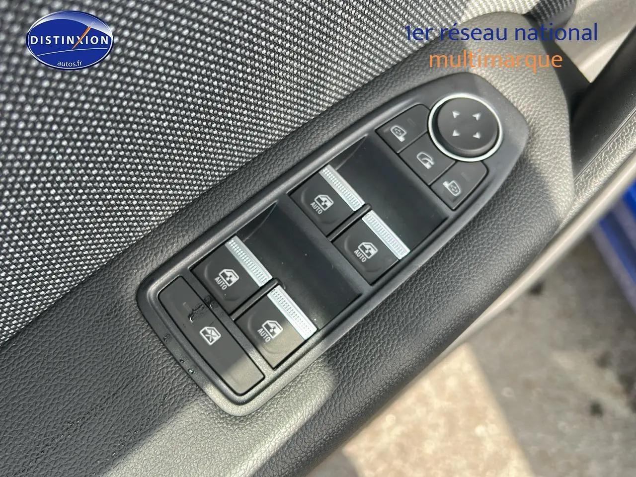 Gros plan sur les commandes de lève-vitres et rétroviseurs sur la porte côté conducteur d’un Renault Captur Bleu Iron.