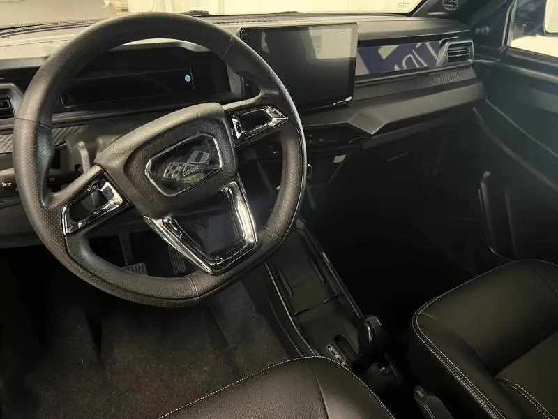 Vue intérieure du poste de conduite de la Ligier JS50 Sport Elite E5+ 2025, volant cuir noir avec inserts chromés.