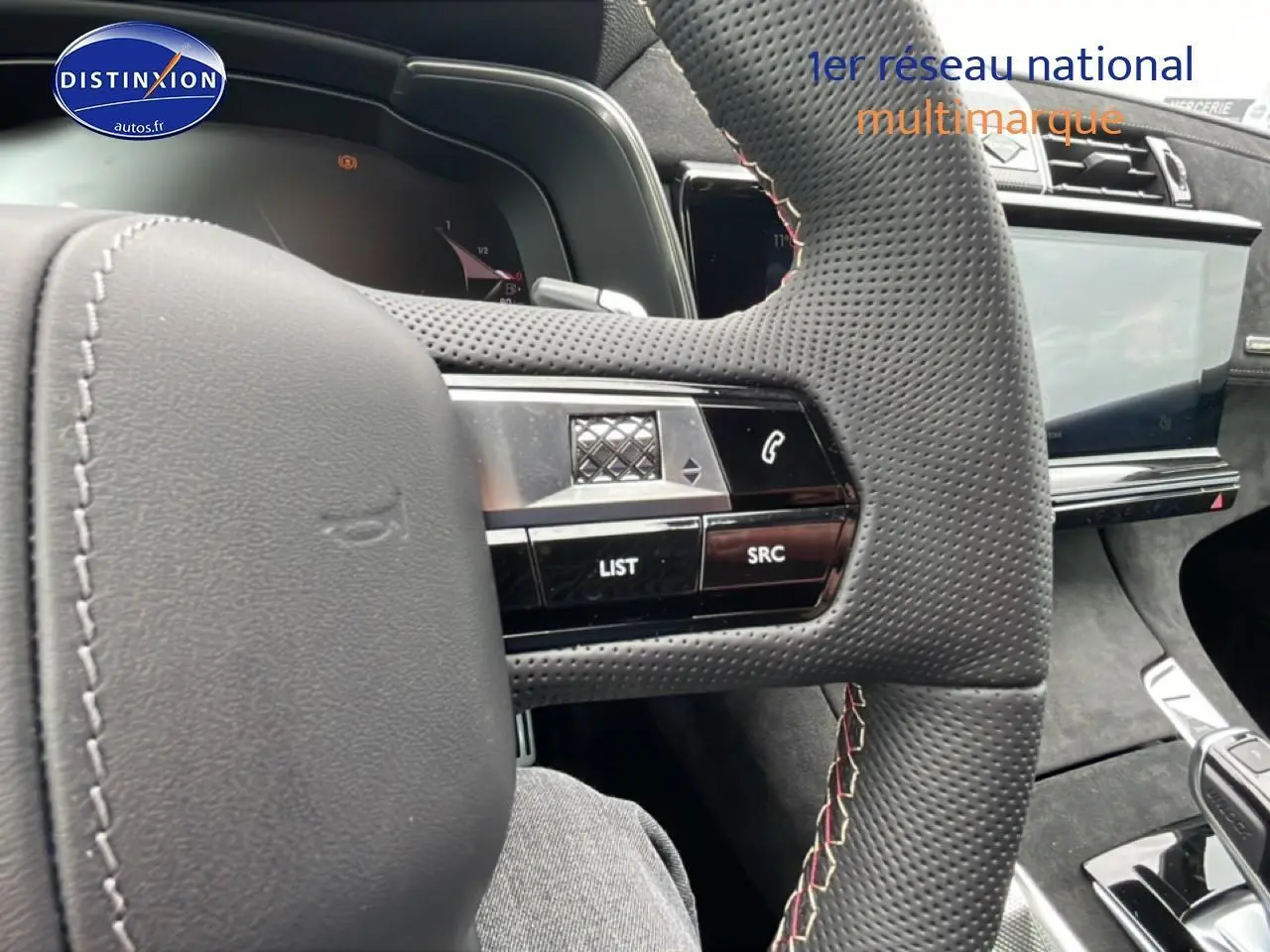 Vue intérieure rapprochée du volant cuir perforé avec commandes intégrées et écran tactile du DS7 gris titane.