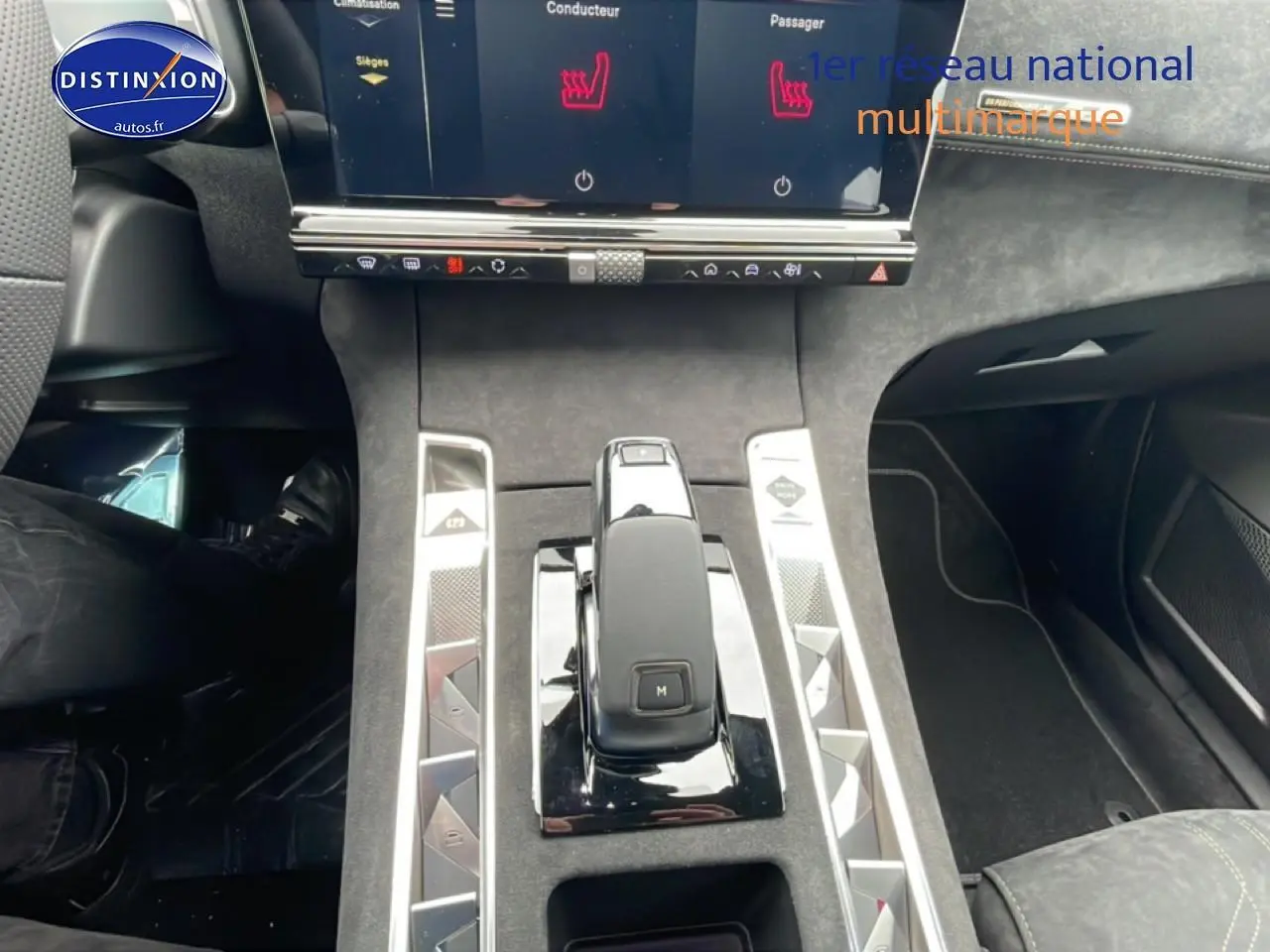 Vue intérieure centrée sur la console centrale du DS7 gris titane, mettant en valeur le levier de vitesses et l'écran tactile.