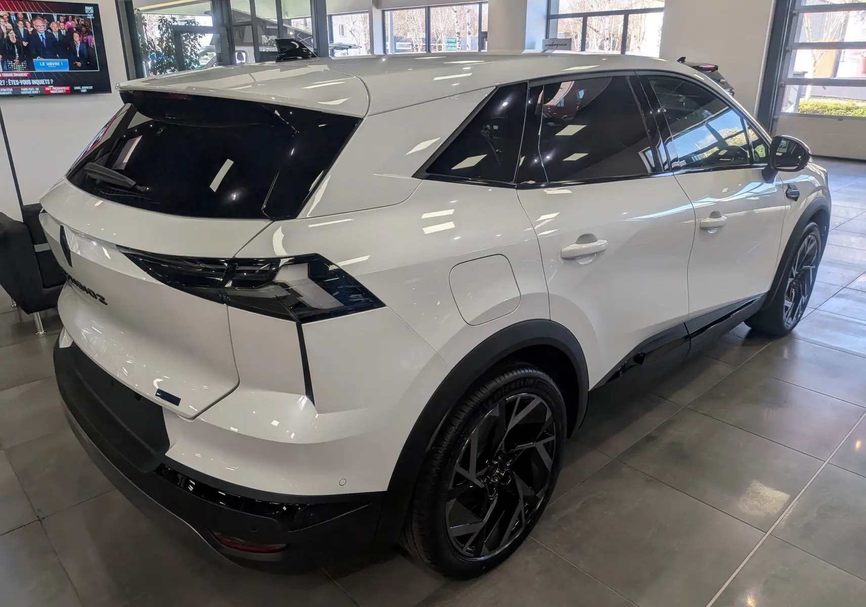 Vue 3/4 arrière droite du Renault SYMBIOZ blanc nacré, avec vitres teintées et jantes noires distinctives.