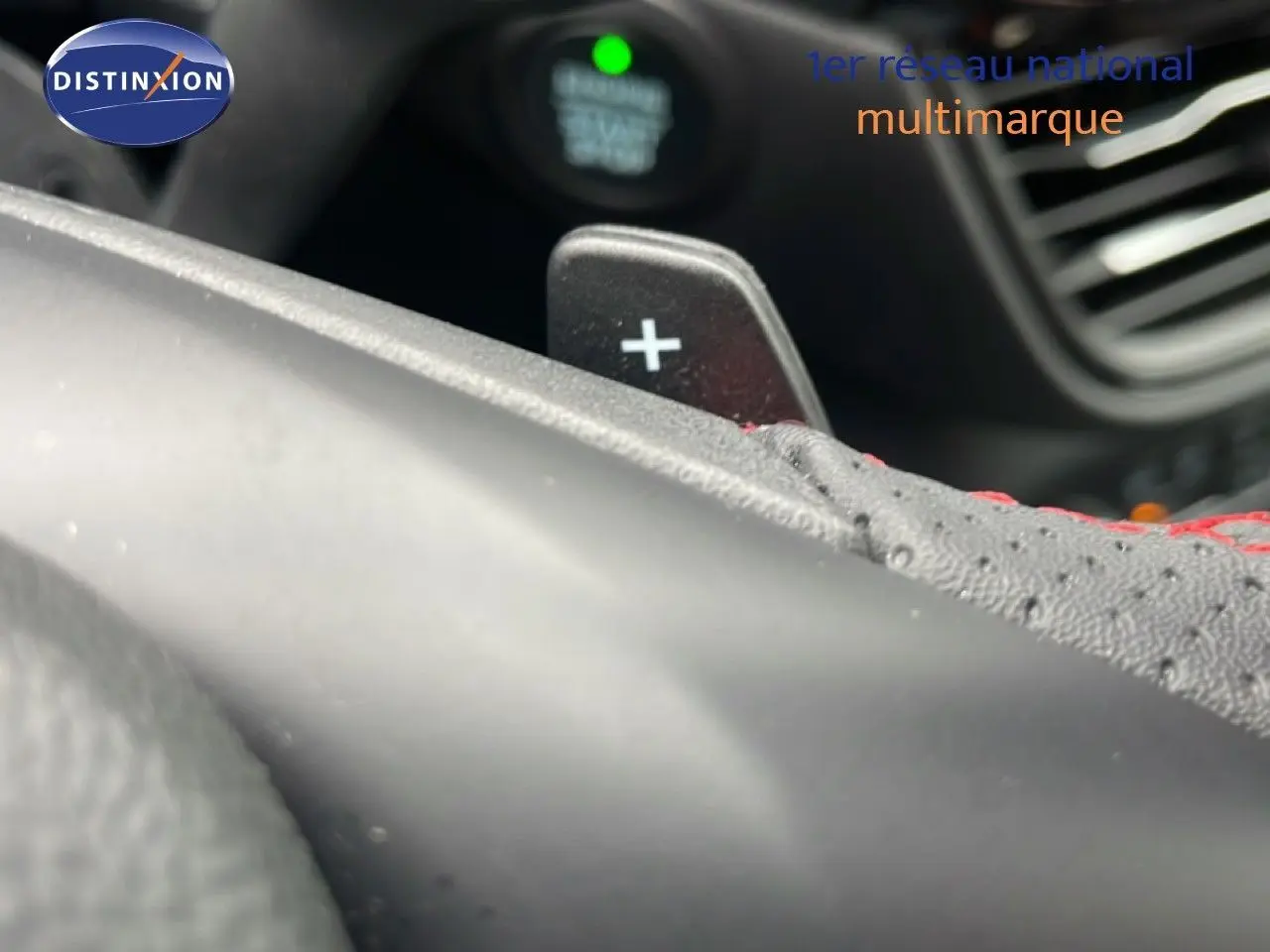 Détail du levier de commande au volant avec surpiqûres rouges dans l'habitacle du Ford Kuga 2024 bleu Vapor Metal.
