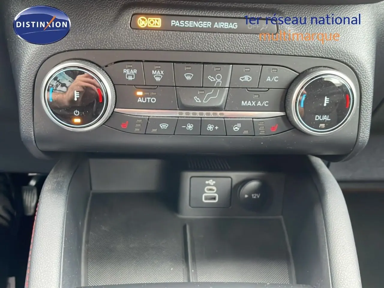 Vue rapprochée du tableau de bord du Ford Kuga 2024, montrant la climatisation automatique et les commandes USB et 12V.