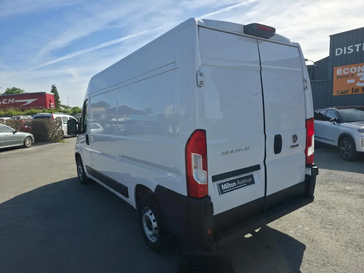Fiat Ducato Fourgon blanc en 3/4 arrière droit, portes arrière tôlées et jantes acier 15 pouces visibles.