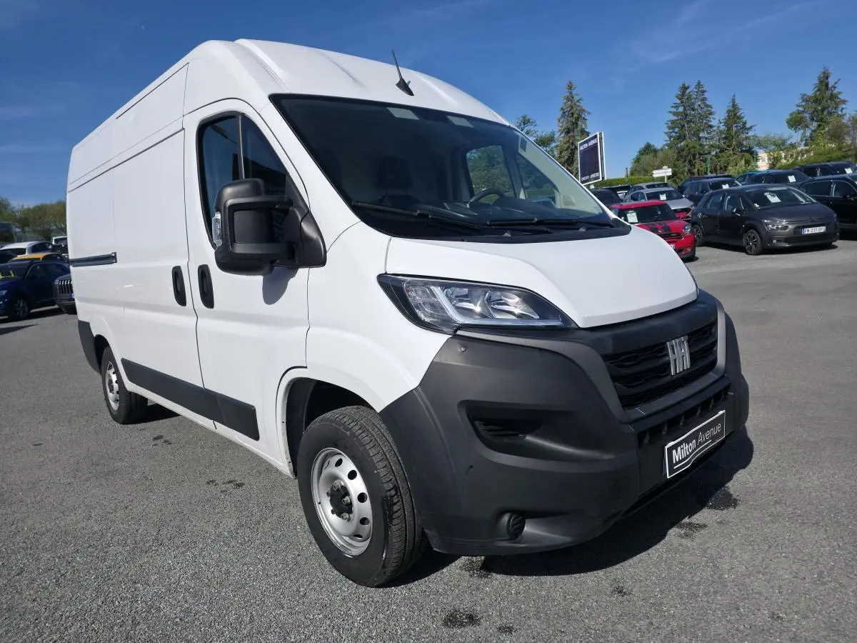 Fiat Ducato Fourgon blanc en 3/4 avant droit, avec calandre noire et jantes acier 15 pouces visibles.