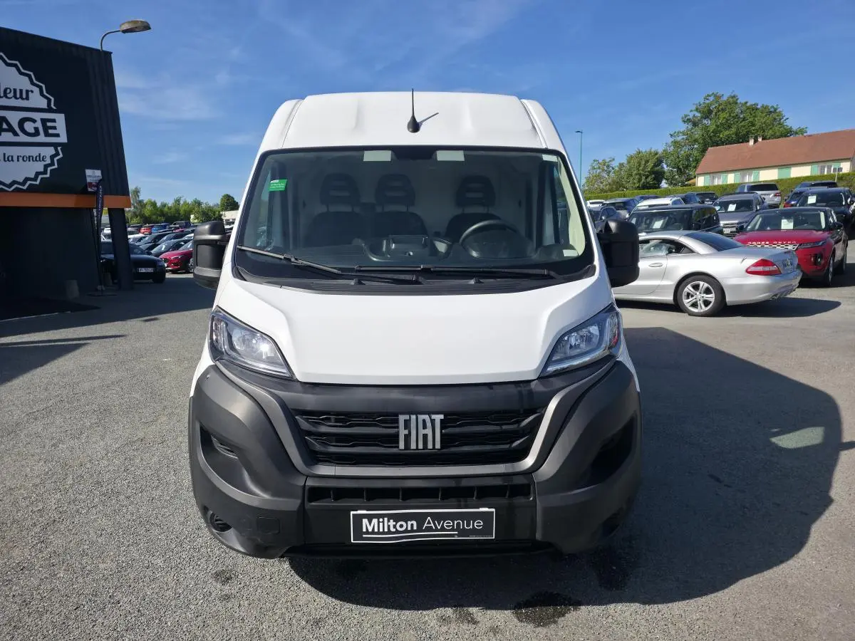 Vue avant d’un FIAT Ducato Fourgon blanc 2023 avec calandre noire et pare-chocs robuste en plastique noir.