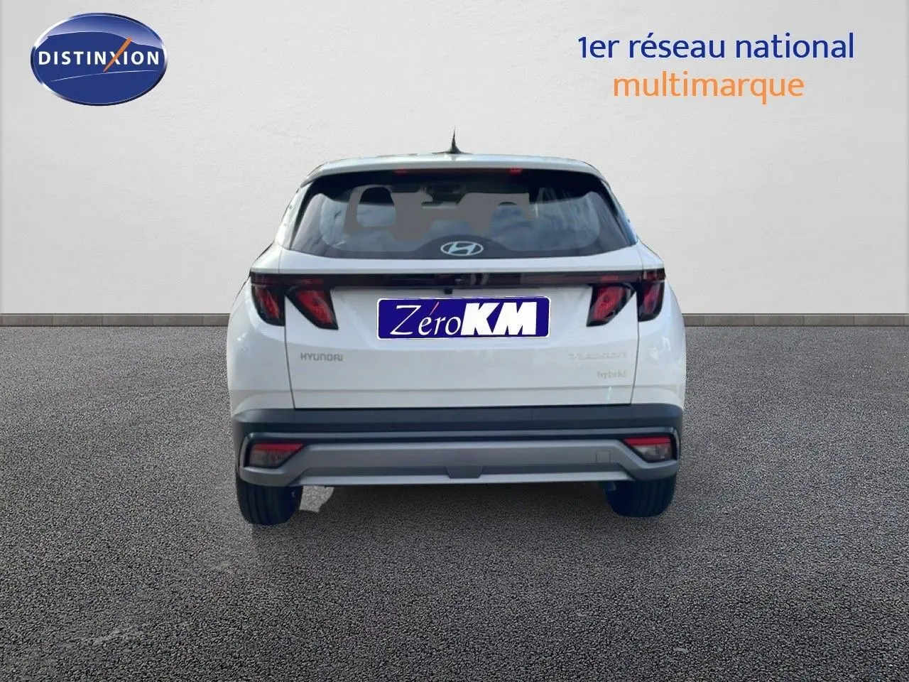 Vue arrière d'un Hyundai Tucson blanc Atlas 2026 avec feux arrière sombres et logo Hyundai visible.