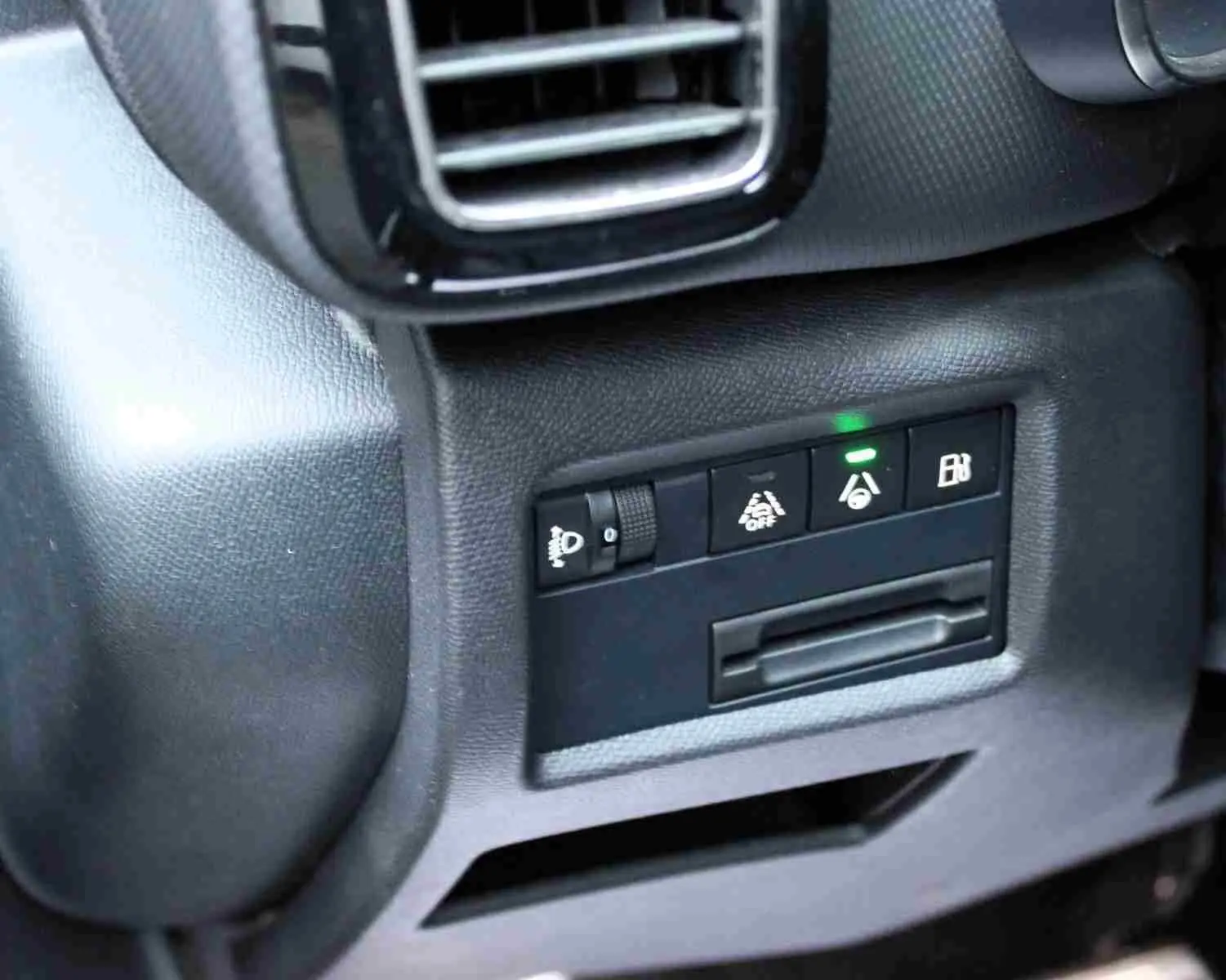 Détail intérieur côté gauche montrant les commandes d'assistance et réglage des phares du Citroën C5 Aircross gris platinium hybride rechargeable.