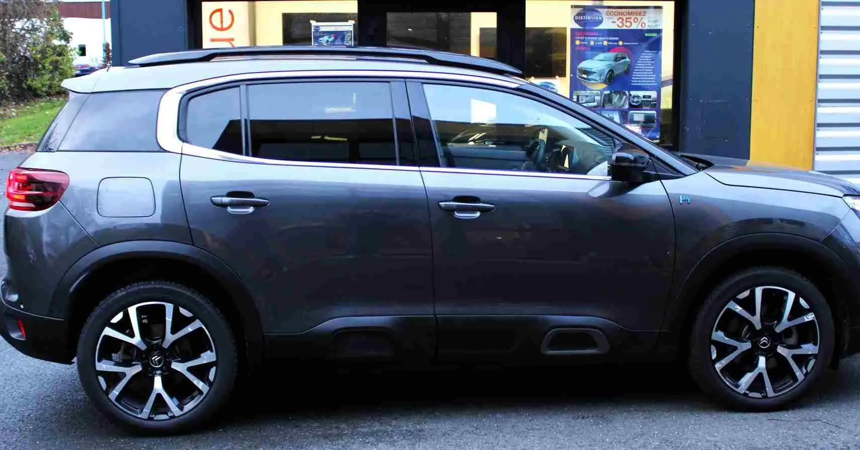 Vue latérale droite d'un Citroën C5 Aircross gris platinium hybride rechargeable, avec jantes alliage et toit noir contrasté.