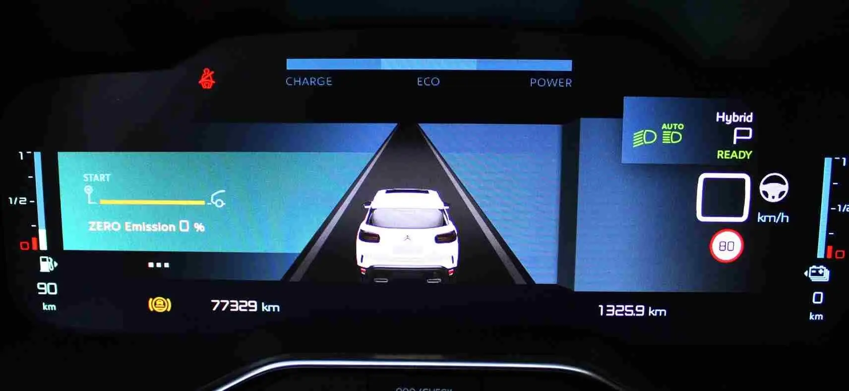 Affichage numérique du tableau de bord du Citroën C5 Aircross hybride, montrant l'icône du véhicule blanc vu de dos et les indicateurs de charge et vitesse.