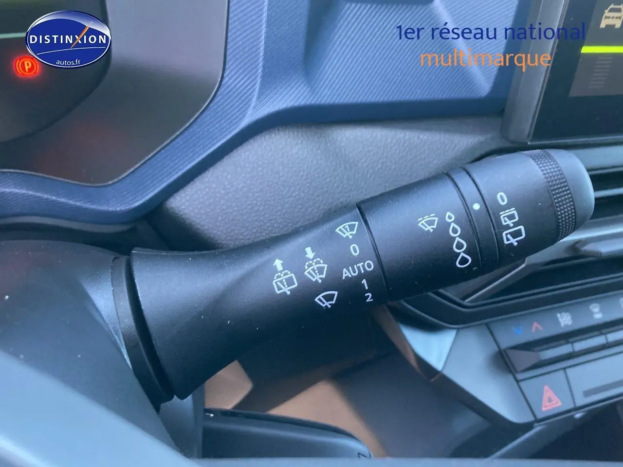 Gros plan sur la commande des essuie-glaces du tableau de bord intérieur du Dacia Duster 2025, détails des symboles blancs.