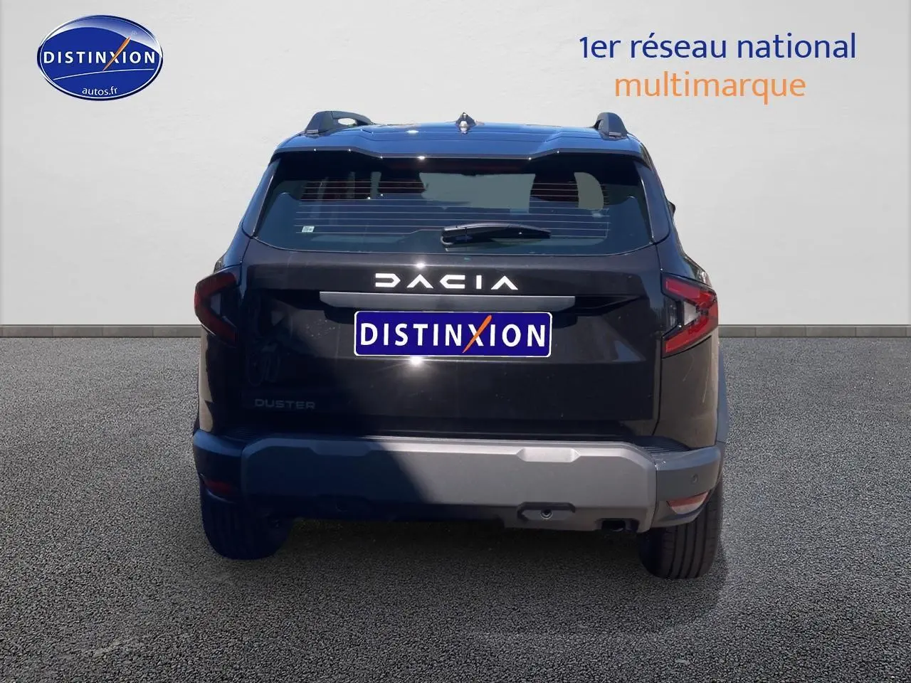 Vue arrière du Dacia Duster noir 2025 avec barres de toit et logo DACIA bien visible.