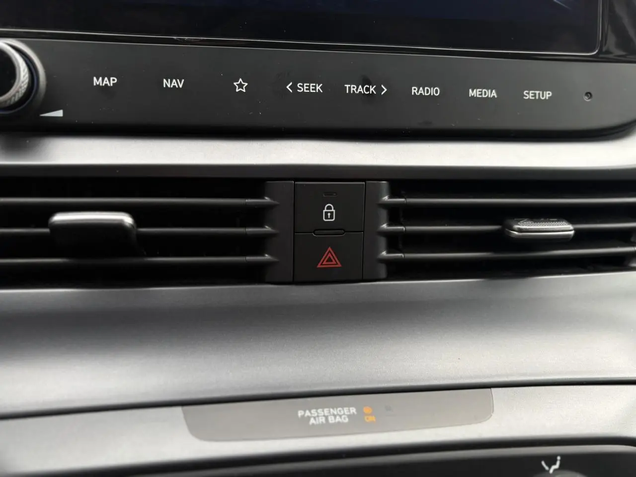Détail du tableau de bord gris avec commandes centrales de ventilation et bouton de verrouillage sur Hyundai i20 2025.