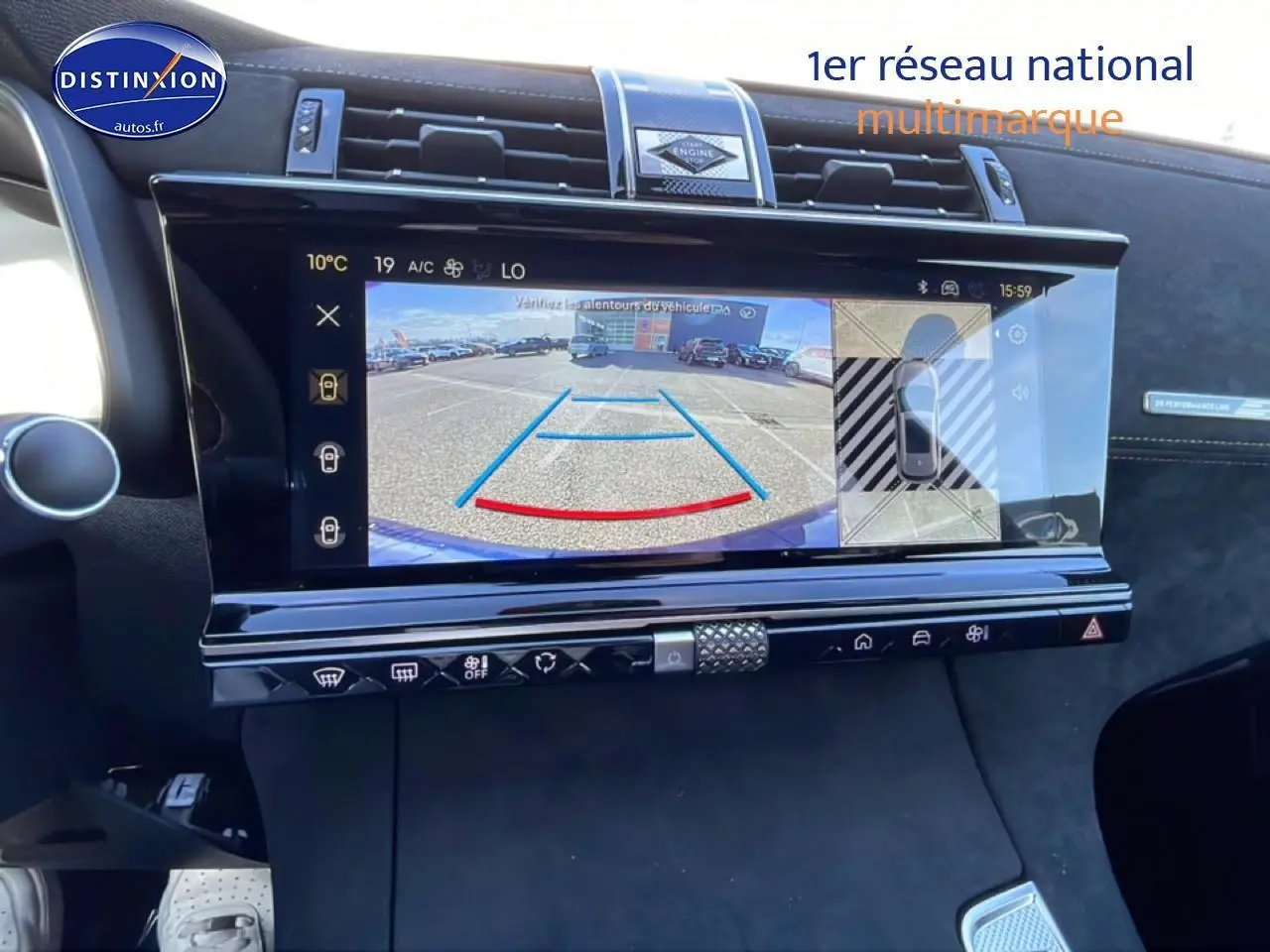 Vue intérieure centrée sur l'écran tactile affichant la caméra de recul du DS7 bleu, avec détails du tableau de bord noir.