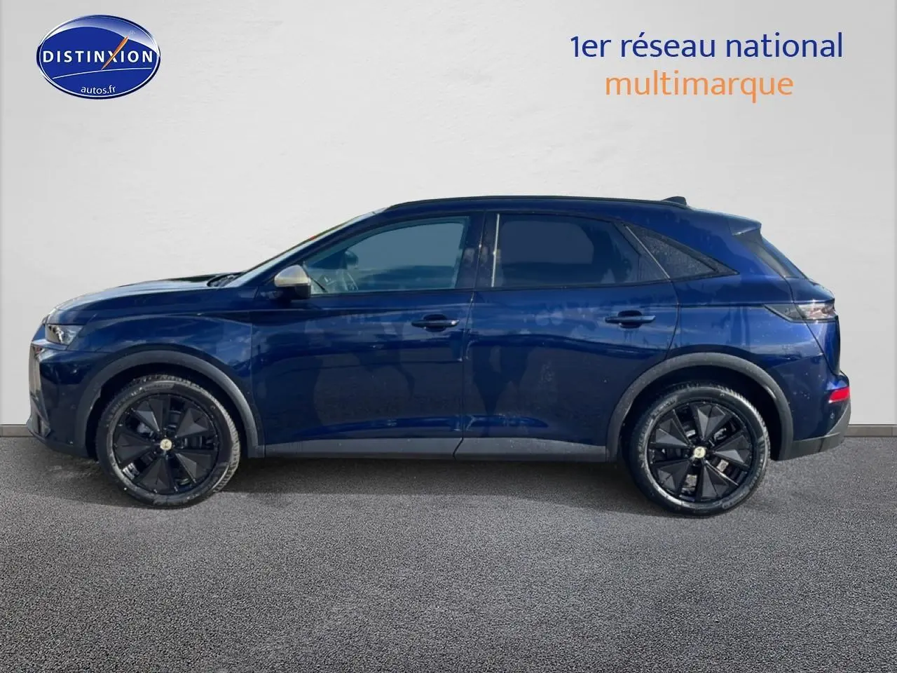 Vue latérale droite d'un DS7 bleu 2026 avec jantes noires et vitres arrière surteintées.