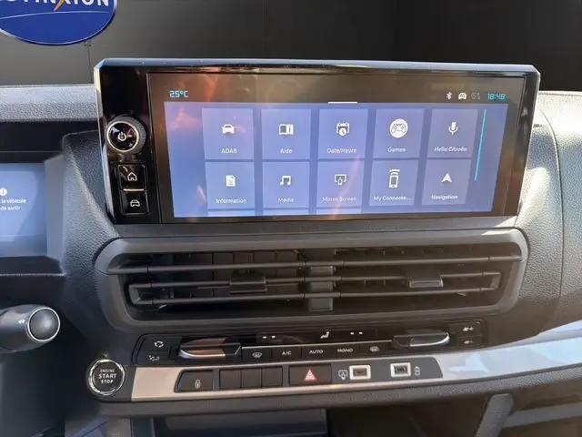 Vue rapprochée de l’écran tactile central et des commandes de climatisation du tableau de bord du Citroën Jumpy gris titane.