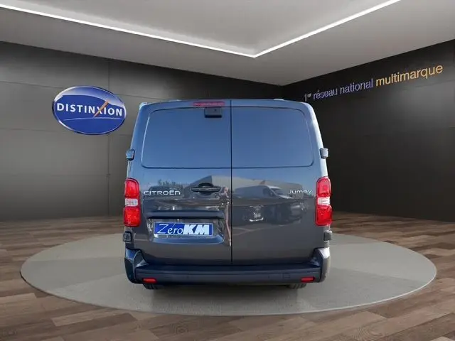 Vue arrière d'un Citroën Jumpy gris titane, avec portes battantes fermées et feux arrière rouges visibles.