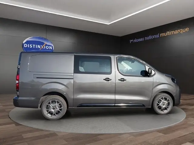 Vue de profil côté gauche du Citroën Jumpy gris titane, version cabine approfondie avec porte latérale coulissante.