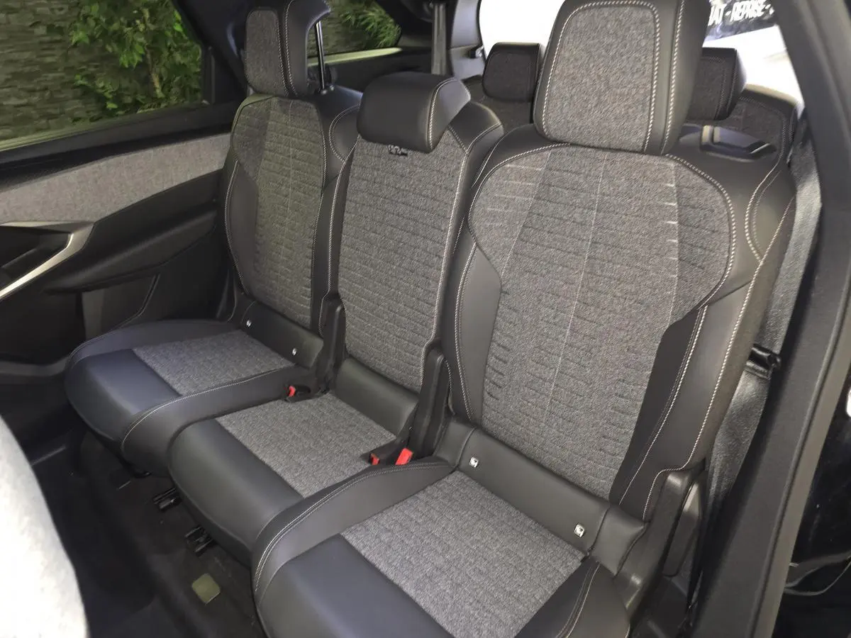 Vue latérale droite sur la banquette arrière tissu gris et cuir noir du Peugeot 5008 noir 2025.