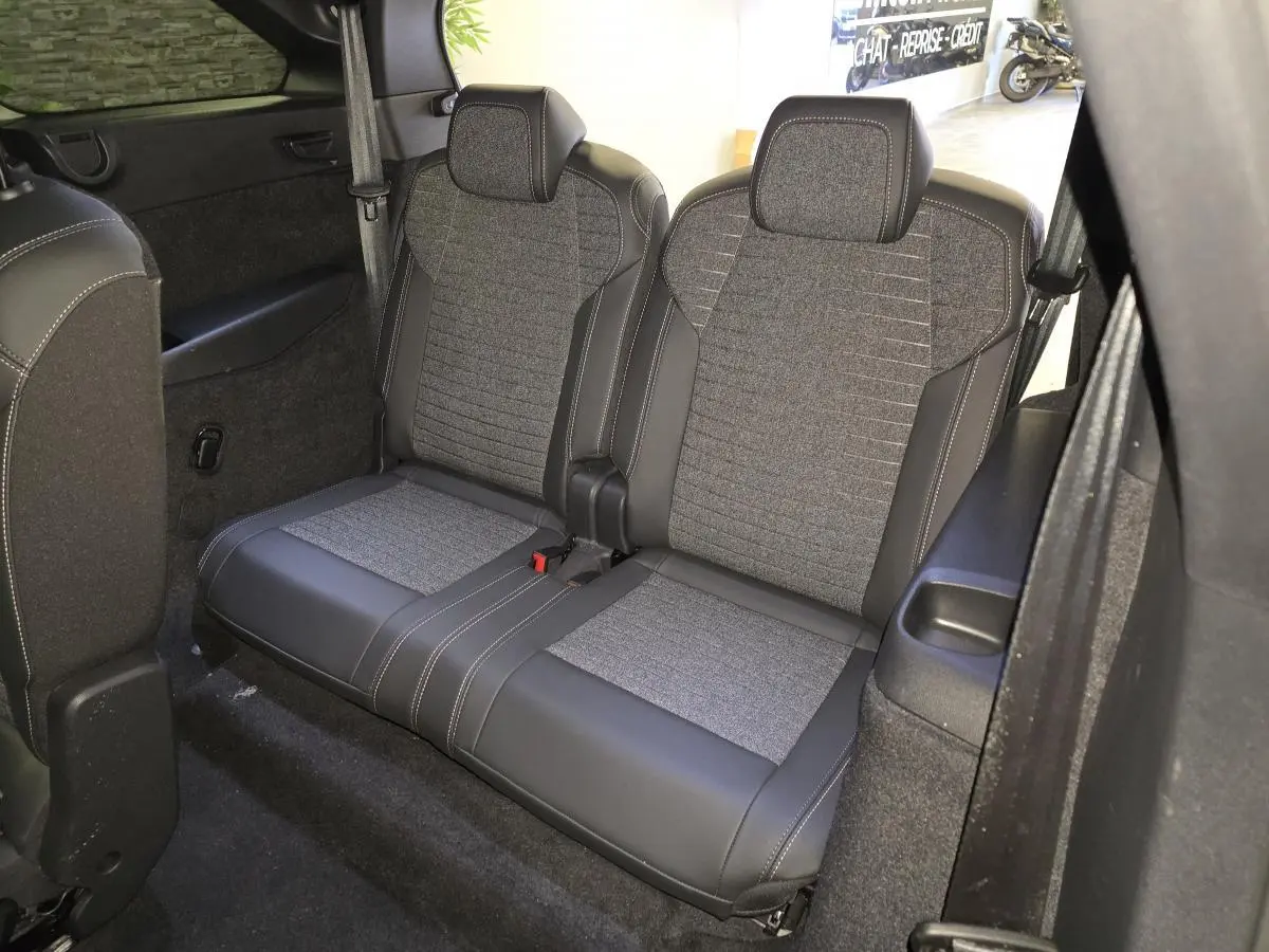 Vue rapprochée de la banquette arrière 2 places en tissu gris et cuir noir du Peugeot 5008 hybride 2025.