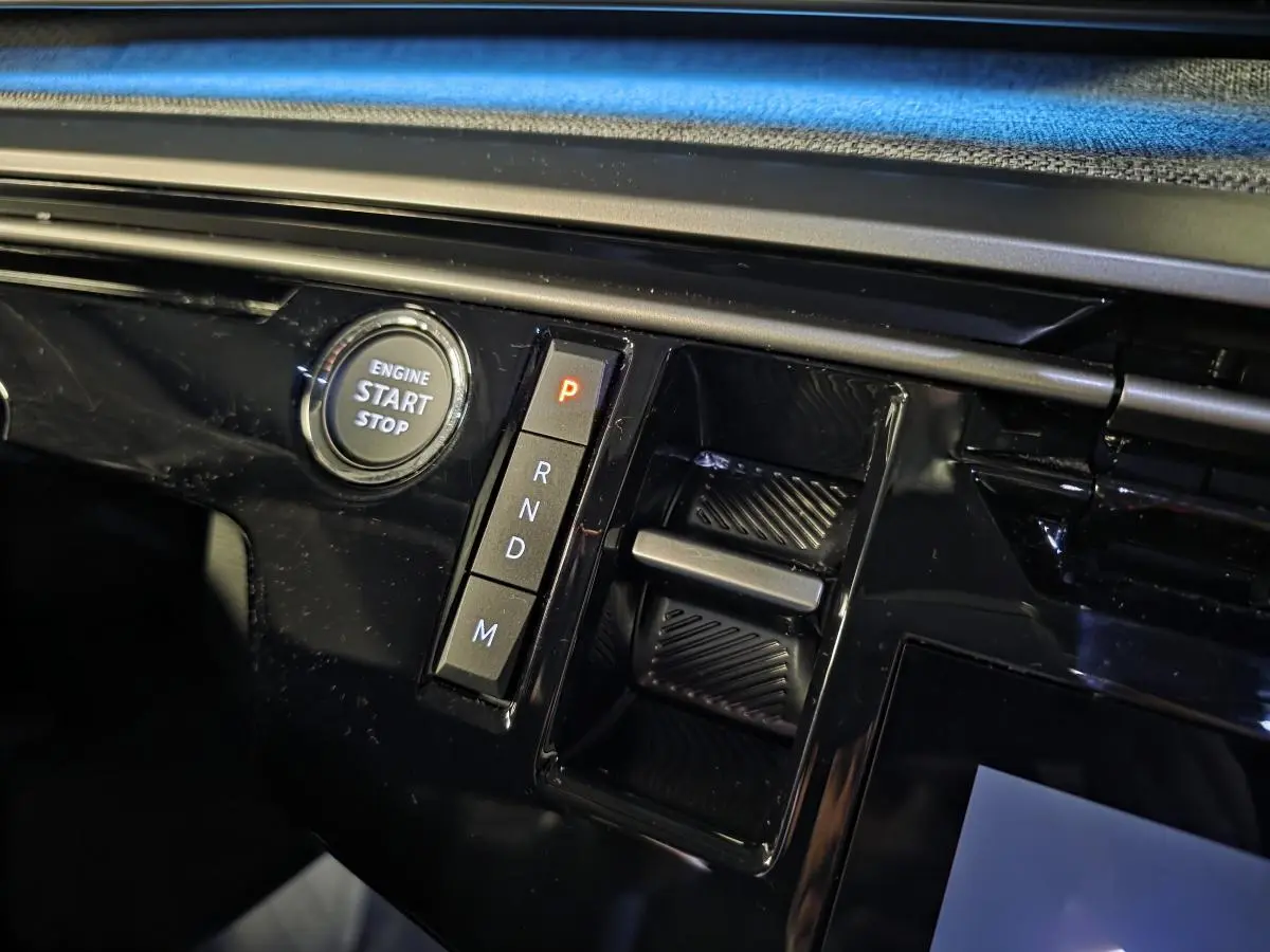 Détail de la console centrale noire brillante du Peugeot 5008 2025 avec bouton start/stop et commandes de boîte auto.