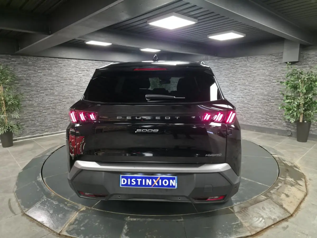 Vue arrière du Peugeot 5008 hybride noir 2025 avec feux arrière LED 3 griffes et bandeau noir laqué.