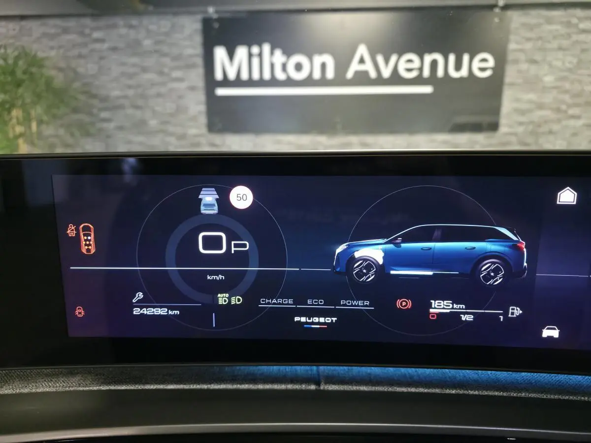 Affichage numérique intérieur du tableau de bord du Peugeot 5008 hybride, montrant une silhouette bleue côté gauche et les informations de conduite.
