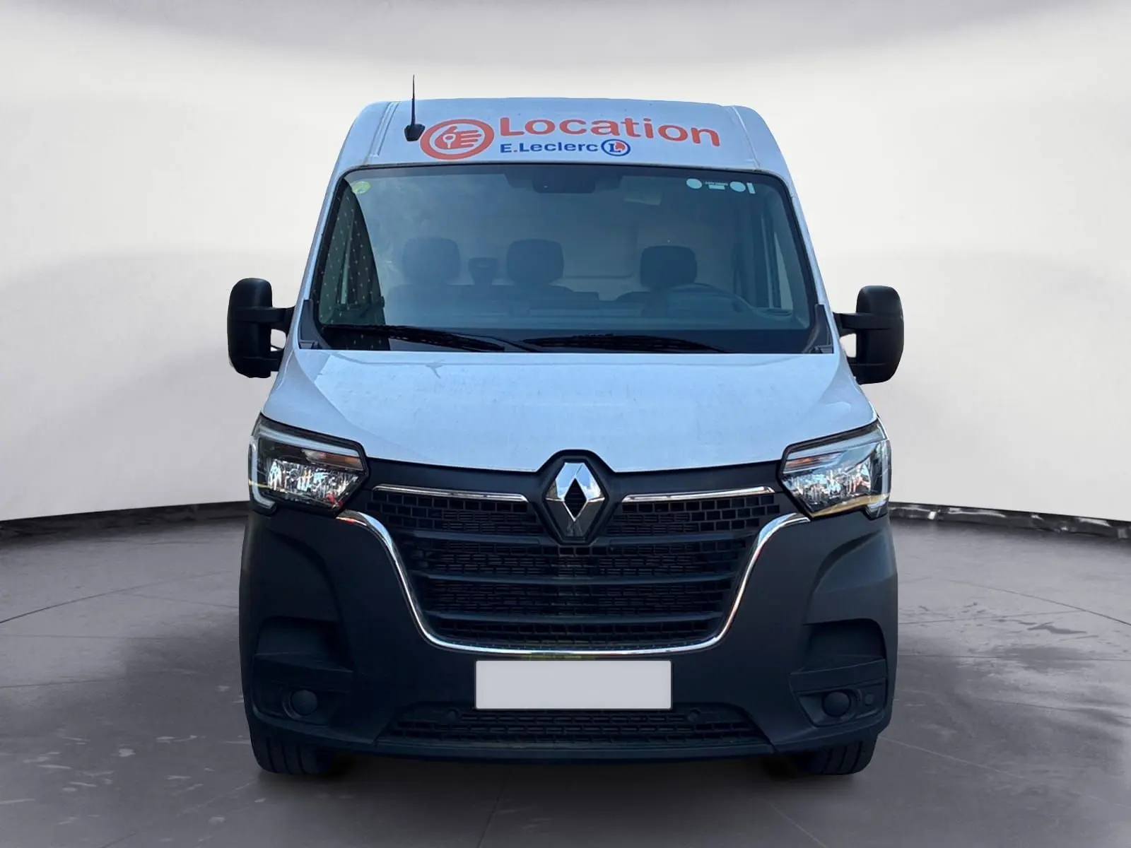 Vue de face du Renault Master blanc 2024 avec logo Renault et marquage "Location E.Leclerc" sur le toit.