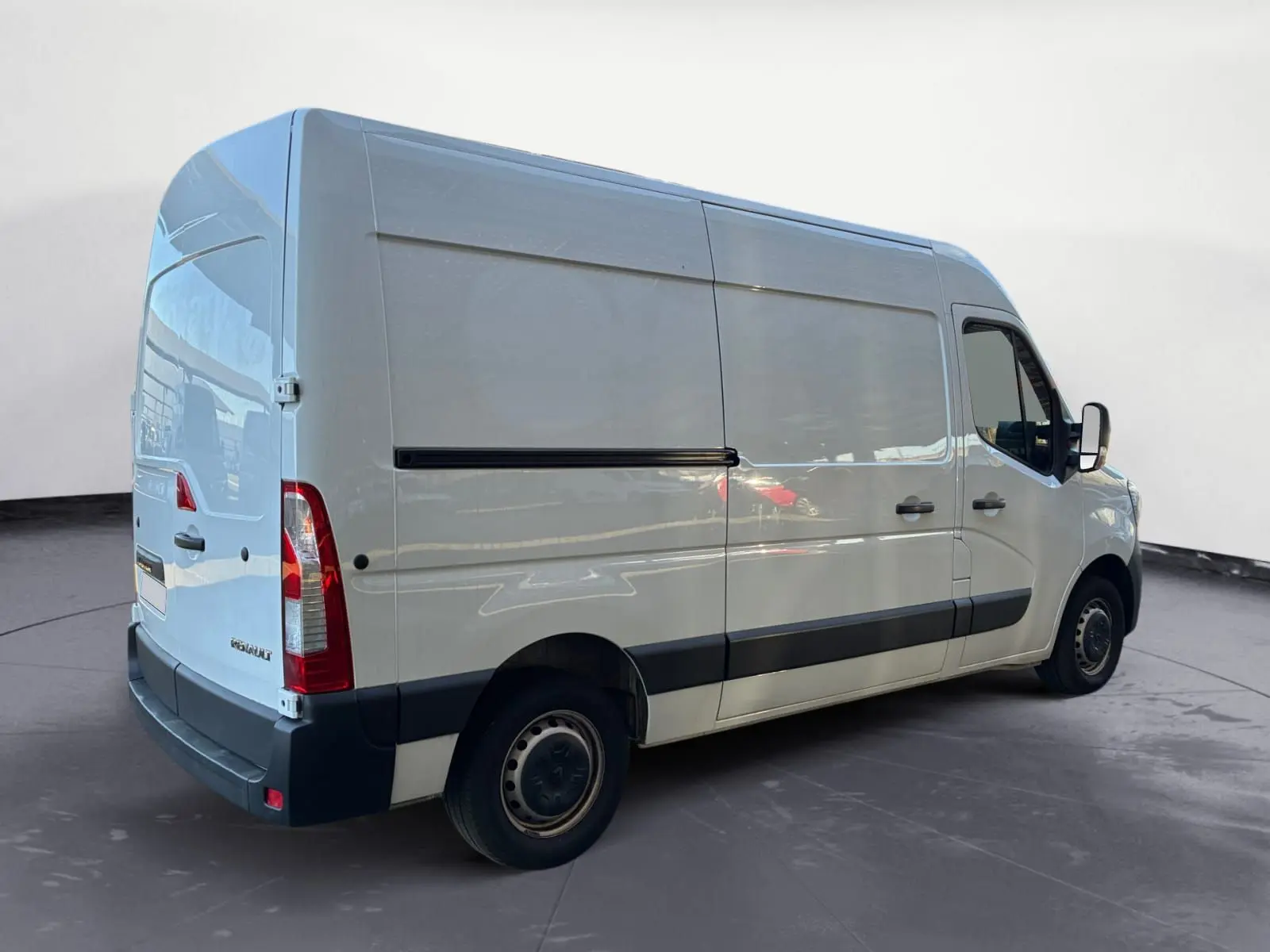 Vue 3/4 arrière droite d’un Renault Master blanc 2024 avec porte latérale coulissante et jantes tôles noires.