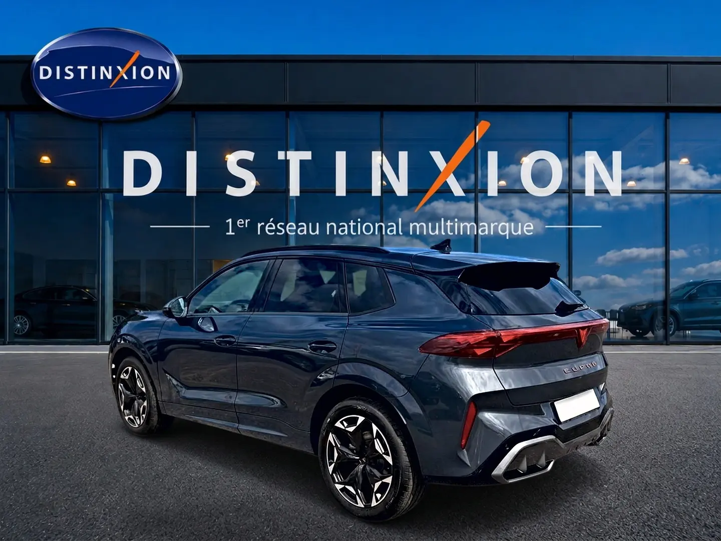 Vue 3/4 arrière droite d'un CUPRA TERRAMAR gris timanfaya avec jantes 19 pouces et feux arrière LED allumés.