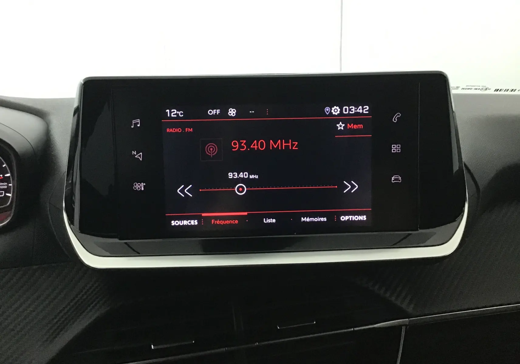 Écran tactile central de la Peugeot 208 noire 2022 affichant la radio FM à 93,40 MHz dans l'habitacle.