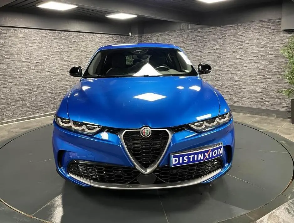 Vue frontale d'une Alfa Romeo Tonale 1.5 mHEV 160 TI bleu métallisé avec calandre caractéristique et rétroviseurs noirs.