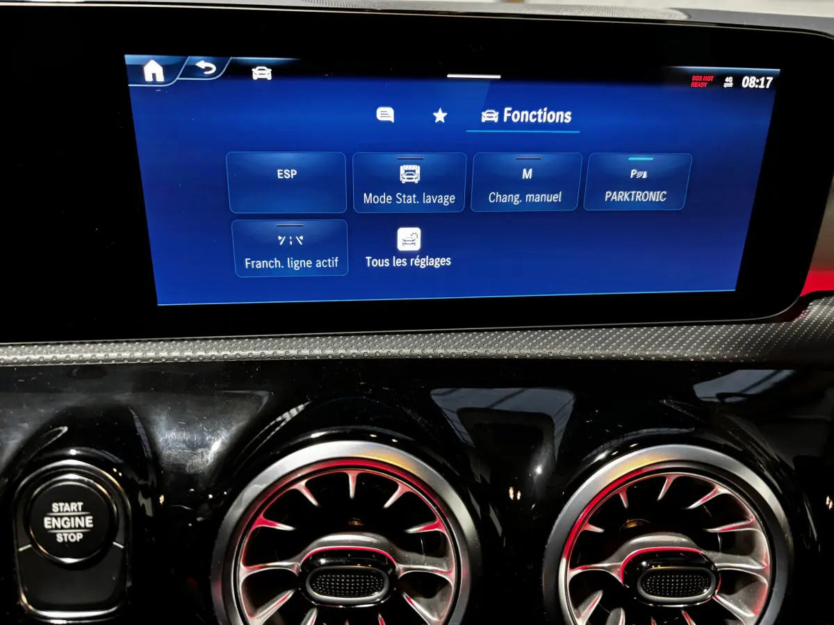 Vue rapprochée du tableau de bord noir brillant de la Mercedes CLA 250 e AMG Line 2023, avec écran tactile affichant les fonctions.