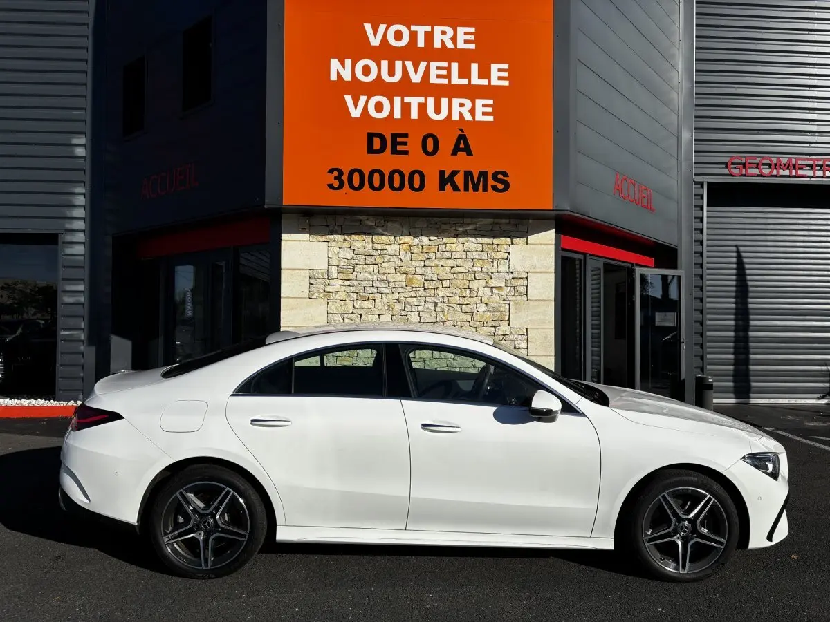 Vue latérale droite d'une Mercedes CLA 250 e AMG Line blanche 2023, avec jantes AMG et silhouette élégante.