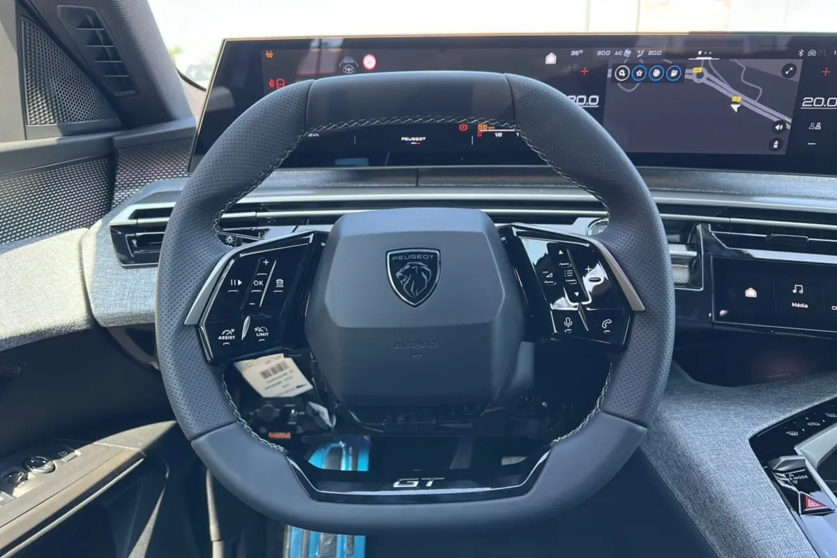 Vue rapprochée du volant cuir multifonctions Peugeot 3008 Hybrid GT avec tableau de bord numérique et finitions Alcantara grises.