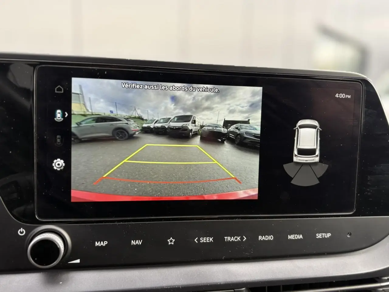 Écran tactile de la Hyundai i20 2025 montrant la caméra de recul avec vue arrière et alertes de proximité.