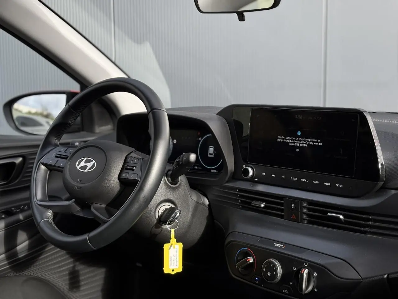 Vue intérieure côté conducteur de la Hyundai i20 2025, volant cuir, tableau de bord numérique et écran tactile central.