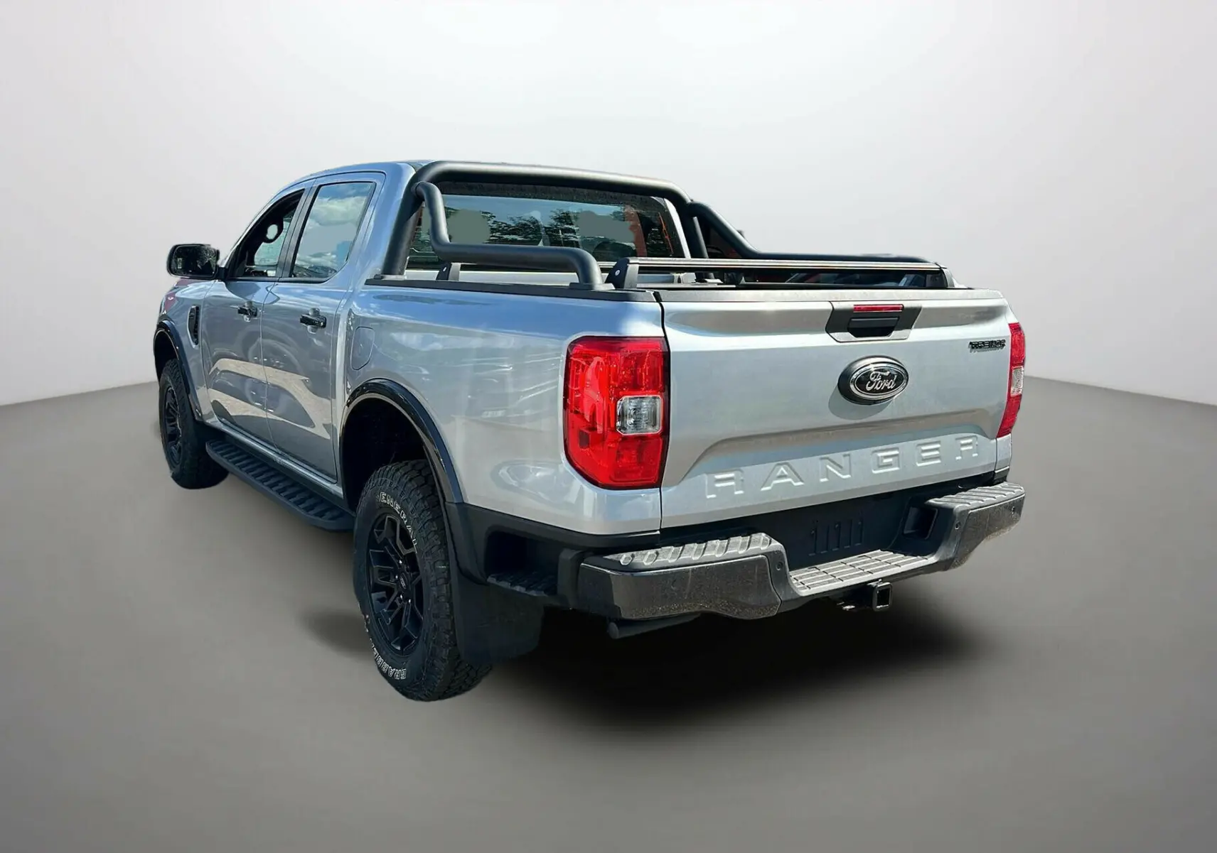 Vue 3/4 arrière droite du Ford Ranger gris iconic avec arceaux noirs et benne ouverte, version Tremor Cover 2025.