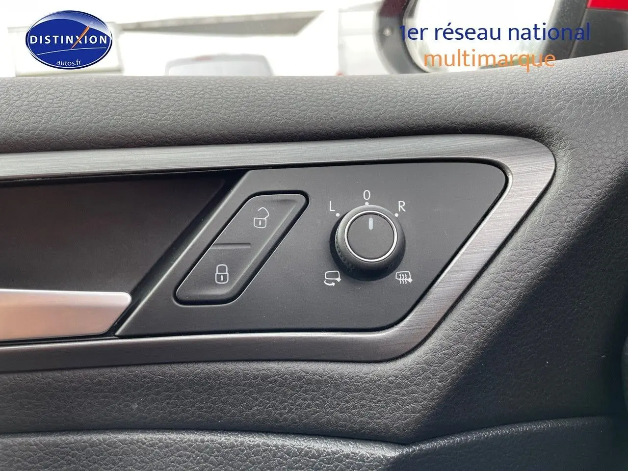 Détail des commandes de réglage des rétroviseurs et verrouillage sur la porte côté conducteur d'une Volkswagen Golf rouge.