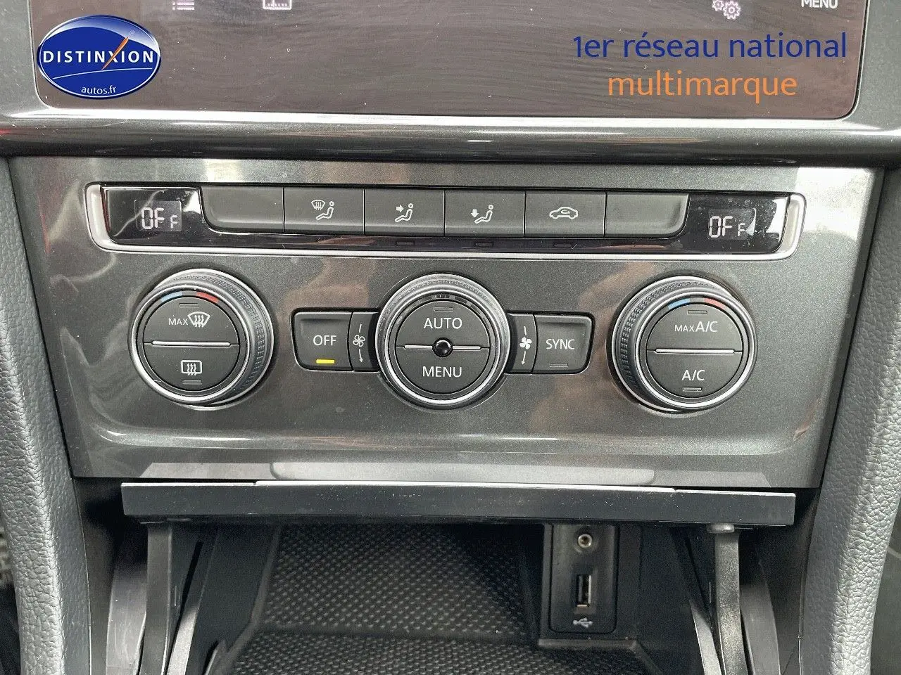 Détail de la console centrale de la Volkswagen Golf VII rouge, montrant les commandes de climatisation et ventilation.